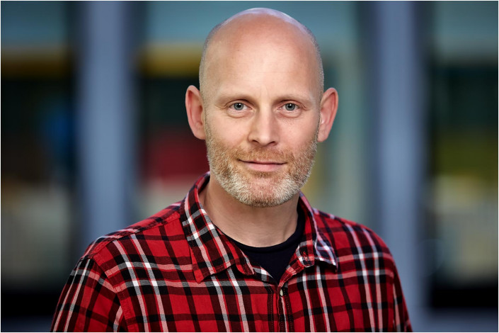 location headshot of a man in checkered shirt